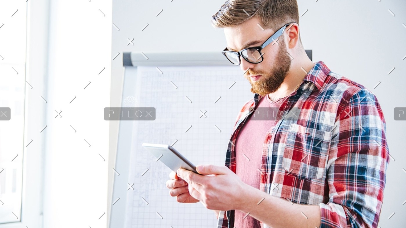 handsome-serious-man-with-beard-standing-and-PBYSCKB