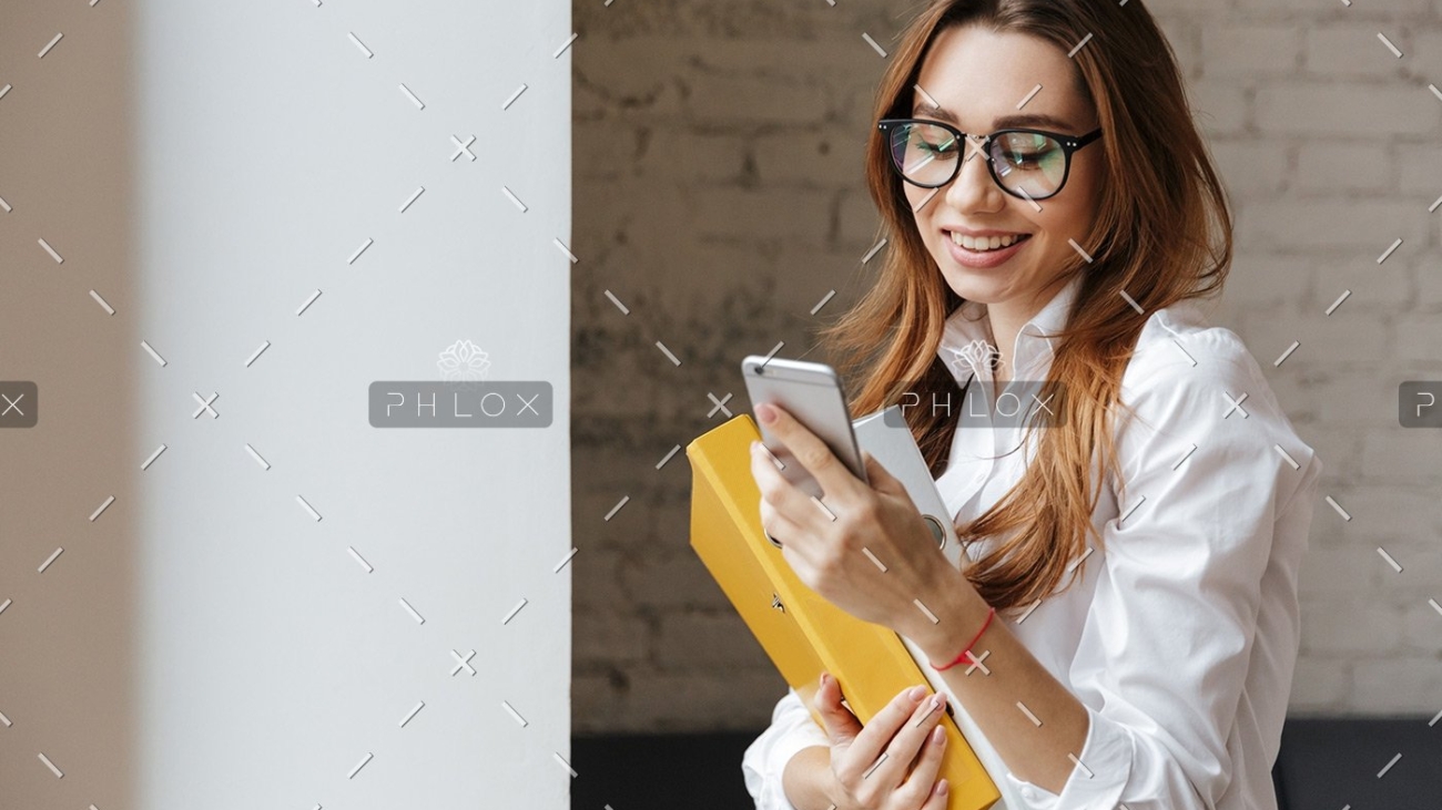 happy-business-woman-indoors-using-mobile-phone-P9WS3SD