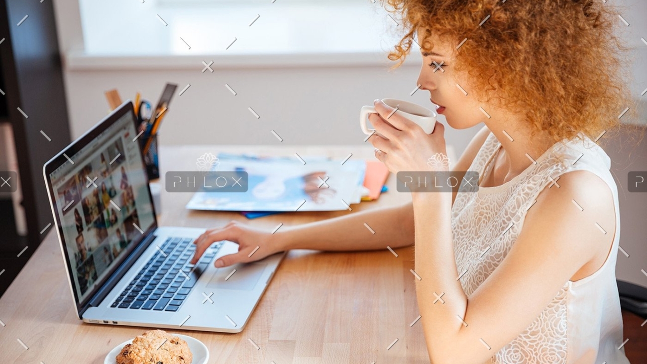 woman-photographer-drinking-coffee-and-working-PJNBP6U